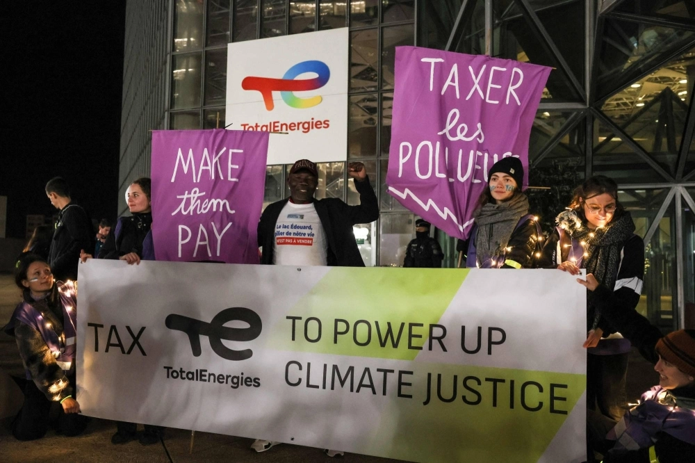 Demonstrators hold banners in front of the TotalEnergies headquarter building at La Defense in Courbevoie, France, on Nov. 3, ahead of the international climate conference COP28 in Dubai later this month. Demonstrators hold banners in front of the TotalEnergies headquarter building at La Defense in Courbevoie, France, on Nov. 3, ahead of the international climate conference COP28 in Dubai later this month.