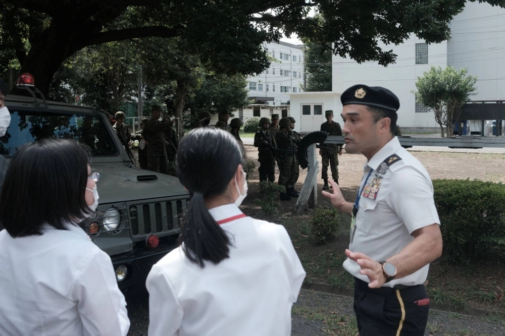 A Self-Defense Forces officer talks to participants in an information session at Camp Nerima in Tokyo on Aug. 7. The SDF raised the maximum age for new recruits to 32 from 26 in 2018 but has still struggled to attract them. A Self-Defense Forces officer talks to participants in an information session at Camp Nerima in Tokyo on Aug. 7. The SDF raised the maximum age for new recruits to 32 from 26 in 2018 but has still struggled to attract them.