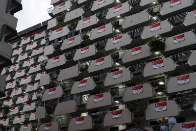 Singapore national flags hang from the facade of a Housing & Development Board public housing estate in the Selegie area of Singapore, in 2021. Singapore national flags hang from the facade of a Housing & Development Board public housing estate in the Selegie area of Singapore, in 2021.