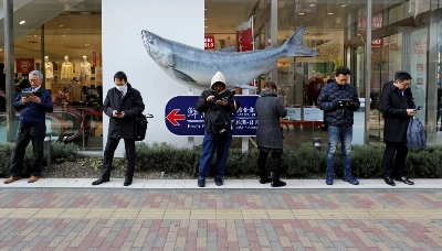 People use smartphones on the street in Tokyo in January 2019. People use smartphones on the street in Tokyo in January 2019.
