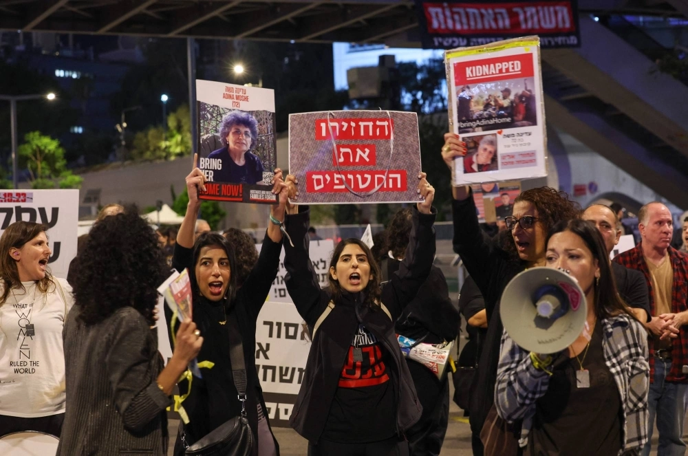 Families of Israeli hostages held by Palestinian militants in the Gaza Strip protest outside the ministry of defense in Tel Aviv on Tuesday.  Families of Israeli hostages held by Palestinian militants in the Gaza Strip protest outside the ministry of defense in Tel Aviv on Tuesday.