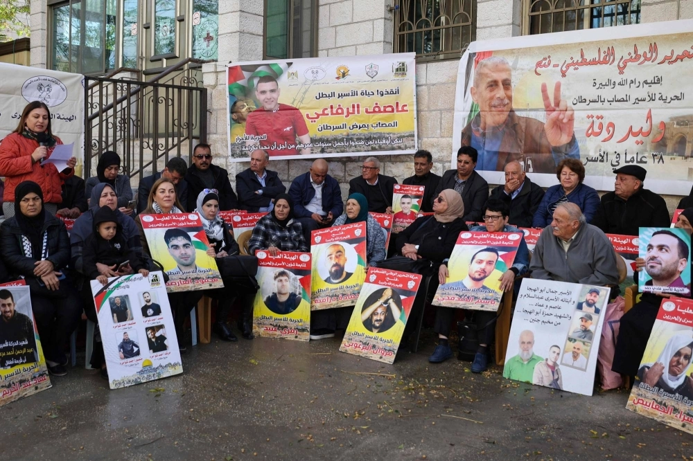 Relatives and supporters of Palestinians held in Israeli prisons stage a sit-in in front of the Red Cross in the West Bank city of Ramallah on Tuesday, calling for a deal to be brokered between Israel and Hamas for their release, in exchange for Israeli hostages taken on the Oct. 7 attack by Hamas militants. Relatives and supporters of Palestinians held in Israeli prisons stage a sit-in in front of the Red Cross in the West Bank city of Ramallah on Tuesday, calling for a deal to be brokered between Israel and Hamas for their release, in exchange for Israeli hostages taken on the Oct. 7 attack by Hamas militants.