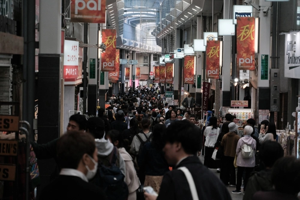 Pedestrians walk past stores in the Koenji district in Tokyo on Oct. 29. Pedestrians walk past stores in the Koenji district in Tokyo on Oct. 29.