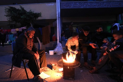 Internally displaced Palestinians keep warm by a fire at a school where they are sheltering in Khan Yunis in the southern Gaza Strip on Tuesday. Internally displaced Palestinians keep warm by a fire at a school where they are sheltering in Khan Yunis in the southern Gaza Strip on Tuesday.