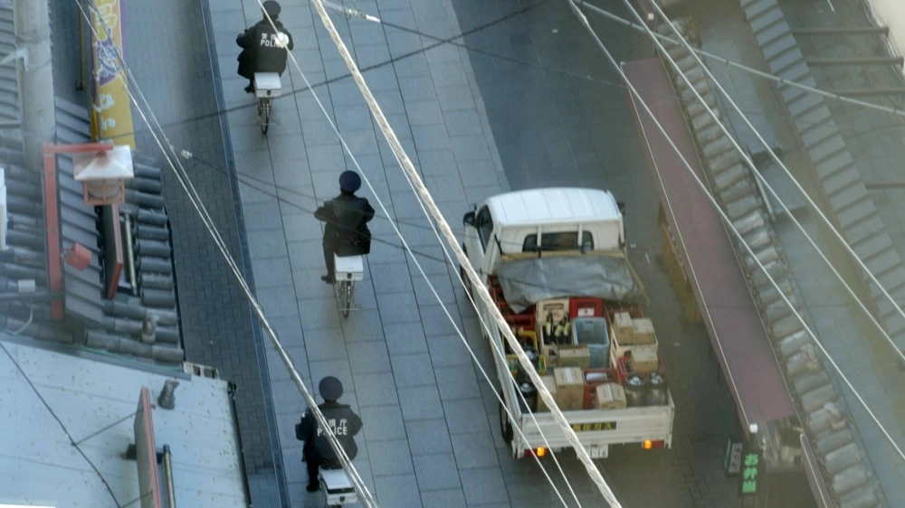 Heidrun Holzfeind documents urban and rural scenes, such as two policemen on bicycles nonchalantly rolling down a street, in her video piece "The 49th Year." The footage is presented alongside incarcerated New Left group leader Toshihiko Kamata’s writings about Japan’s highly supervised society in the exhibition "News from K." Heidrun Holzfeind documents urban and rural scenes, such as two policemen on bicycles nonchalantly rolling down a street, in her video piece "The 49th Year." The footage is presented alongside incarcerated New Left group leader Toshihiko Kamata’s writings about Japan’s highly supervised society in the exhibition "News from K."