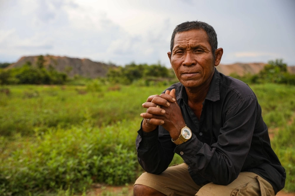 Boy Troch lives next to the Yun Khean coal mine in Cambodia’s Oddar Meanchey province. As with many residents of Anlong Veng, Troch served under the Khmer Rouge’s last holdout commander Ta Mok. Today, he’s a farmer and grandfather who sports a gold watch bearing the image of former Prime Minister Hun Sen. Boy Troch lives next to the Yun Khean coal mine in Cambodia’s Oddar Meanchey province. As with many residents of Anlong Veng, Troch served under the Khmer Rouge’s last holdout commander Ta Mok. Today, he’s a farmer and grandfather who sports a gold watch bearing the image of former Prime Minister Hun Sen.