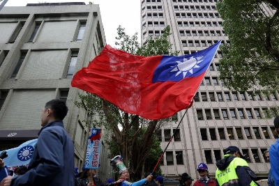 A supporter of the Kuomintang, Taiwan's main opposition party, waves the island's flag outside the Central Election Commission office in Taipei on Friday. A supporter of the Kuomintang, Taiwan's main opposition party, waves the island's flag outside the Central Election Commission office in Taipei on Friday.