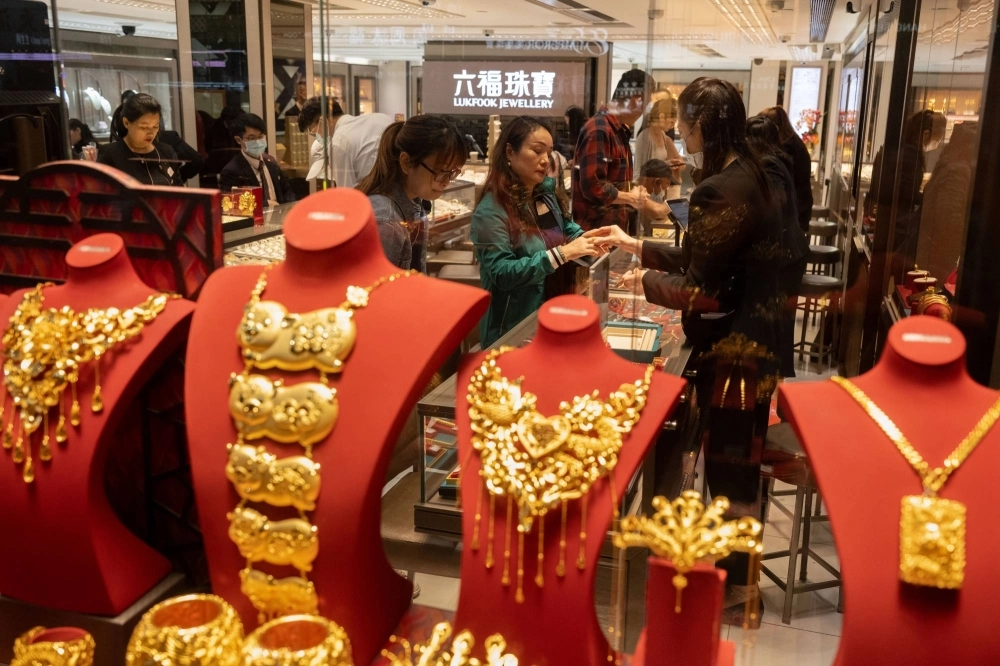 Chinese tourists buy gold bars and gold accessories at LukFook, a jewelry store, in Hong Kong.  Chinese tourists buy gold bars and gold accessories at LukFook, a jewelry store, in Hong Kong.
