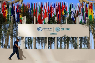 A man walks past national flags of participating countries at the venue of the COP28 climate summit in Dubai on Thursday. A man walks past national flags of participating countries at the venue of the COP28 climate summit in Dubai on Thursday.