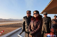 North Korean leader Kim Jong Un and his daughter observe an air festival during a visit with the 1st Air Force Division Flying Regiment of the Korean People's Army to commemorate Air Day, at an unknown location on Thursday. | KCNA / KNS / VIA AFP-JIJI