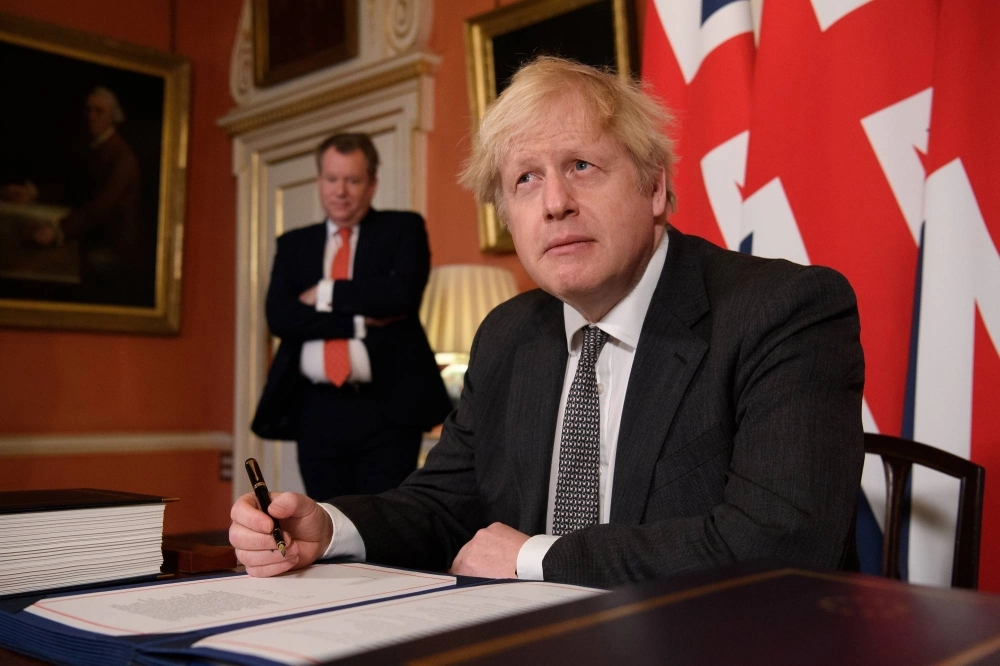 Former British Prime Minister Boris Johnson signing the Brexit trade deal with the EU in London on Dec. 30, 2020. Former British Prime Minister Boris Johnson signing the Brexit trade deal with the EU in London on Dec. 30, 2020.
