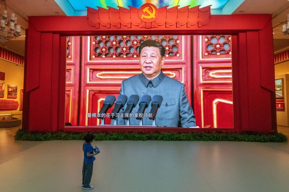 A young boy watches a screen showing Chinese President Xi Jinping at the Military Museum in Beijing. A young boy watches a screen showing Chinese President Xi Jinping at the Military Museum in Beijing.