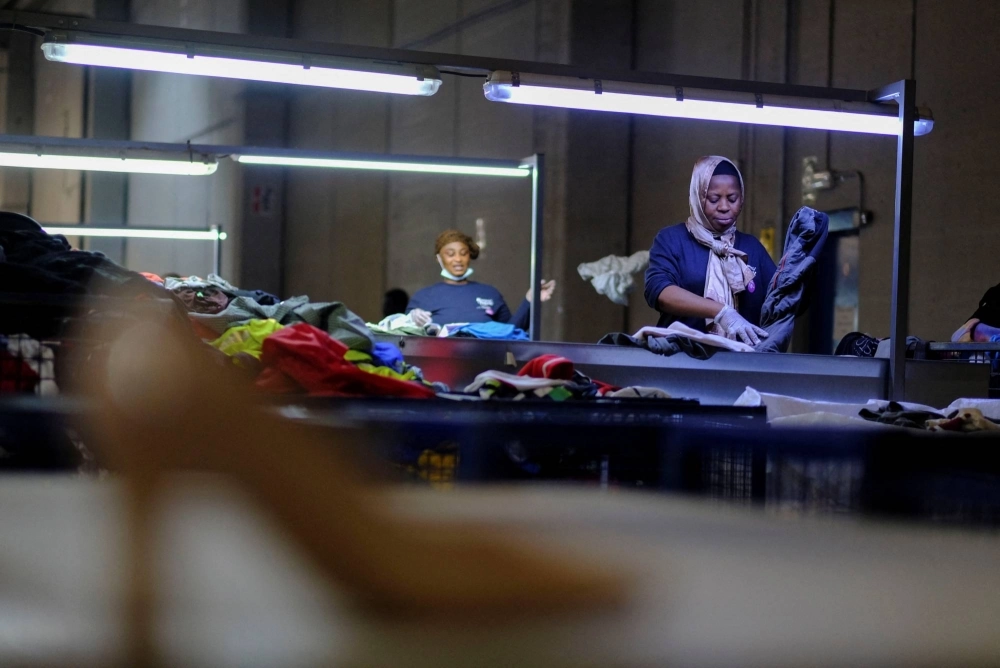 Workers organize used clothing for packaging at a warehouse near Barcelona on Aug. 1. Workers organize used clothing for packaging at a warehouse near Barcelona on Aug. 1.