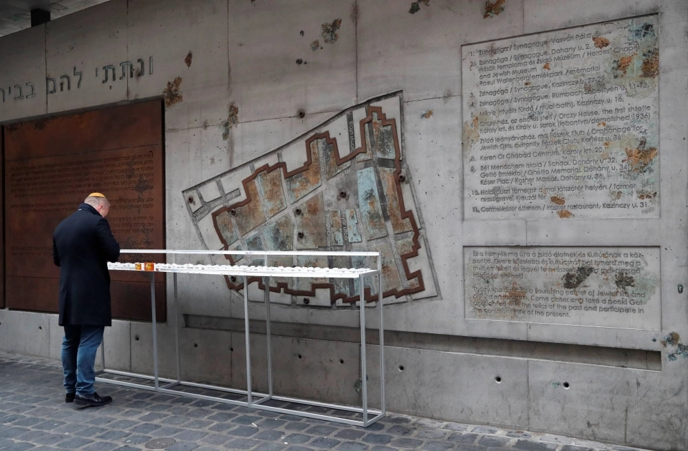 A man stands in front of the Memorial Ghetto Wall in Budapest, which features a map carved into the concrete that shows the outline of a Jewish ghetto decreed in the city in 1944. Around 70,000 Jews were packed into the area, which featured 4,000 apartments with an average occupancy of 14 per room. Others were forced to survive on the streets. A man stands in front of the Memorial Ghetto Wall in Budapest, which features a map carved into the concrete that shows the outline of a Jewish ghetto decreed in the city in 1944. Around 70,000 Jews were packed into the area, which featured 4,000 apartments with an average occupancy of 14 per room. Others were forced to survive on the streets.