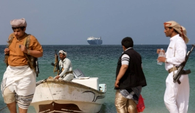 Armed men stand on a beach as the Galaxy Leader commercial ship, seized by Yemen's Houthis last month, is anchored off the coast of al-Salif, Yemen, on Dec. 5. Armed men stand on a beach as the Galaxy Leader commercial ship, seized by Yemen's Houthis last month, is anchored off the coast of al-Salif, Yemen, on Dec. 5.