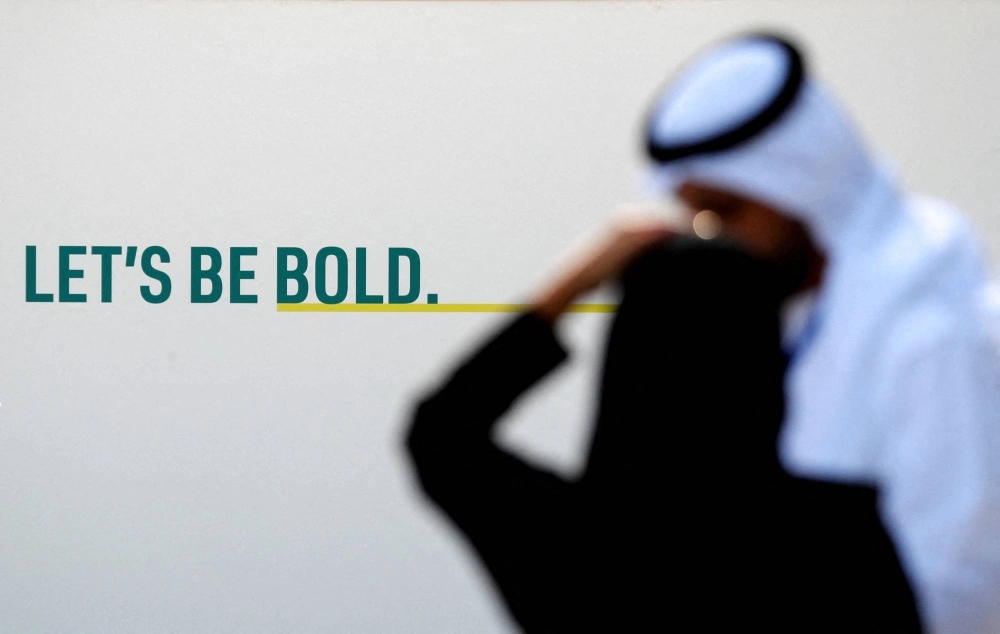 Delegates talk near a sign at Dubai's Expo City during the United Nations Climate Change Conference COP28 in Dubai on Dec. 9.  Delegates talk near a sign at Dubai's Expo City during the United Nations Climate Change Conference COP28 in Dubai on Dec. 9.