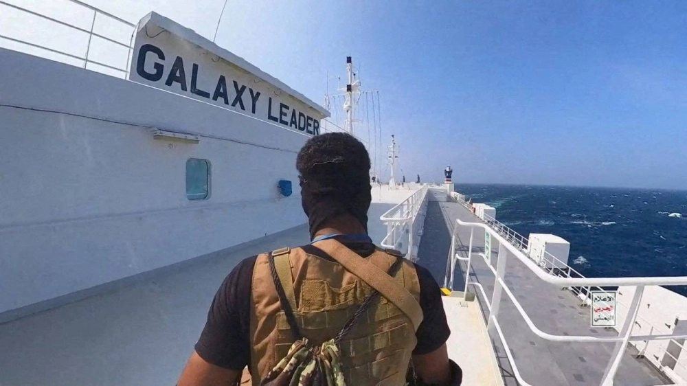A Houthi fighter stands on the Galaxy Leader cargo ship in the Red Sea in this photo released Nov. 20.  A Houthi fighter stands on the Galaxy Leader cargo ship in the Red Sea in this photo released Nov. 20.