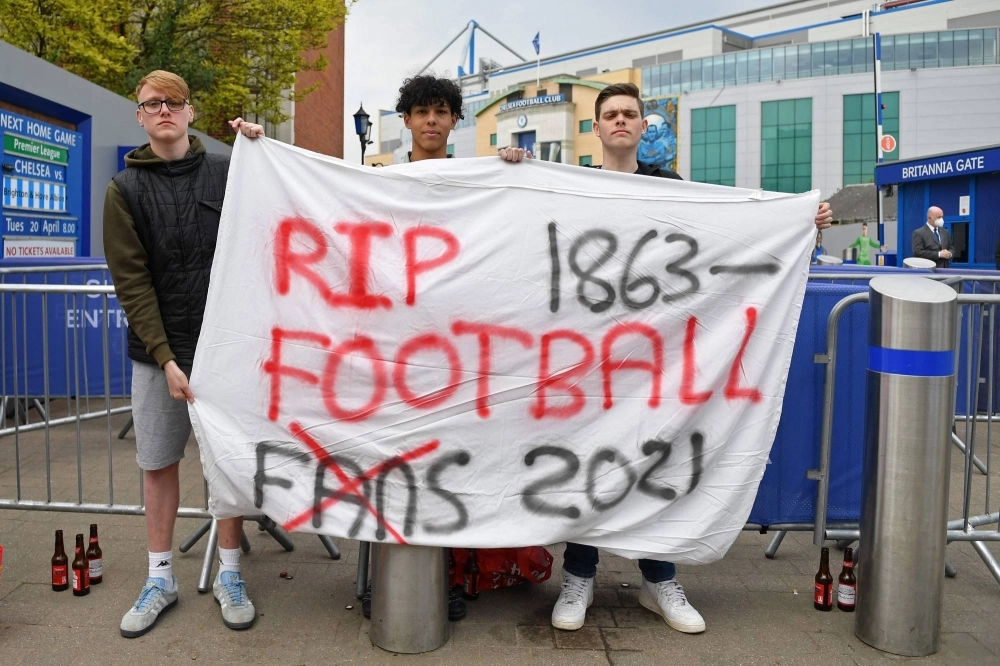 Protesters against the proposal for a new European Super League outside Chelsea's Stamford Bridge Stadium in London in April 2021.  Protesters against the proposal for a new European Super League outside Chelsea's Stamford Bridge Stadium in London in April 2021.