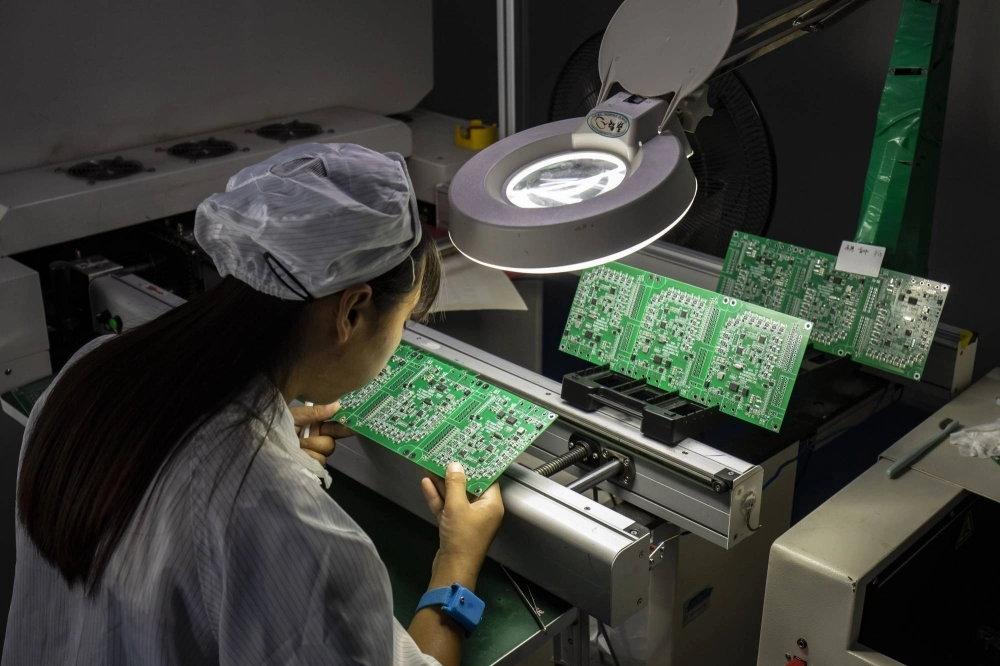 An employee inspects integrated circuit boards at a factory in Suzhou, China. An employee inspects integrated circuit boards at a factory in Suzhou, China.