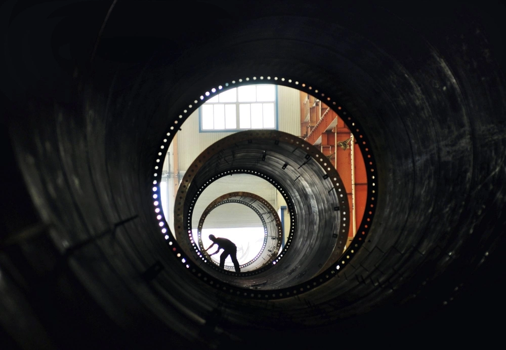 A worker builds the components of wind turbines at a factory in Zouping, China. A worker builds the components of wind turbines at a factory in Zouping, China.