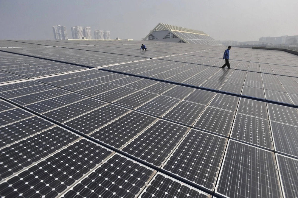 Technicians work on a roof covered with solar panels at a plant in Wuhan, China.  Technicians work on a roof covered with solar panels at a plant in Wuhan, China.