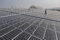 Technicians work on a roof covered with solar panels at a plant in Wuhan, China.  | China Daily / via Reuters