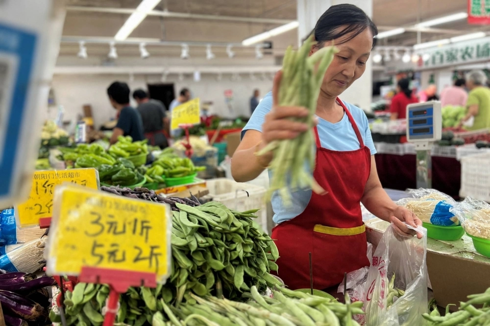 A vegetable vendor at a wet market in Beijing on Aug. 10. The Chinese economy was in focus throughout the year, with a lingering real estate downturn, a difficult geopolitical environment and a slow recovery from the COVID-19 pandemic all weighing on the world’s No. 2 economy. A vegetable vendor at a wet market in Beijing on Aug. 10. The Chinese economy was in focus throughout the year, with a lingering real estate downturn, a difficult geopolitical environment and a slow recovery from the COVID-19 pandemic all weighing on the world’s No. 2 economy.