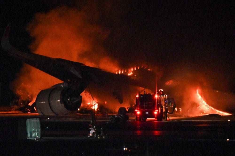 A Japan Airlines (JAL) passenger plane burns on the tarmac at Tokyo's Haneda Airport on Tuesday. A Japan Airlines (JAL) passenger plane burns on the tarmac at Tokyo's Haneda Airport on Tuesday.