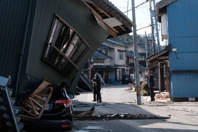 A damaged vehicle under a collapsed house following an earthquake in Nanao, Ishikawa Prefecture, on Tuesday. Speculation that the Bank of Japan might shift its policy this month is receding, as the central bank has to assess the adverse impact from the Noto Peninsula disaster on the economy. A damaged vehicle under a collapsed house following an earthquake in Nanao, Ishikawa Prefecture, on Tuesday. Speculation that the Bank of Japan might shift its policy this month is receding, as the central bank has to assess the adverse impact from the Noto Peninsula disaster on the economy.