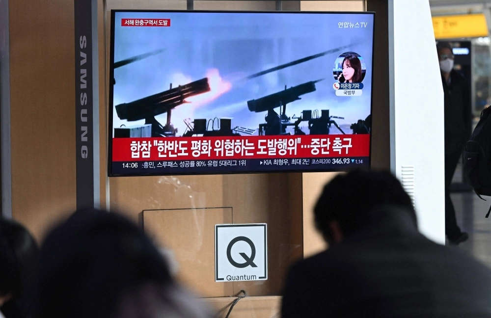 People watch a news broadcast showing file footage of North Korea firing artillery, at a railway station in Seoul on Friday. People watch a news broadcast showing file footage of North Korea firing artillery, at a railway station in Seoul on Friday.