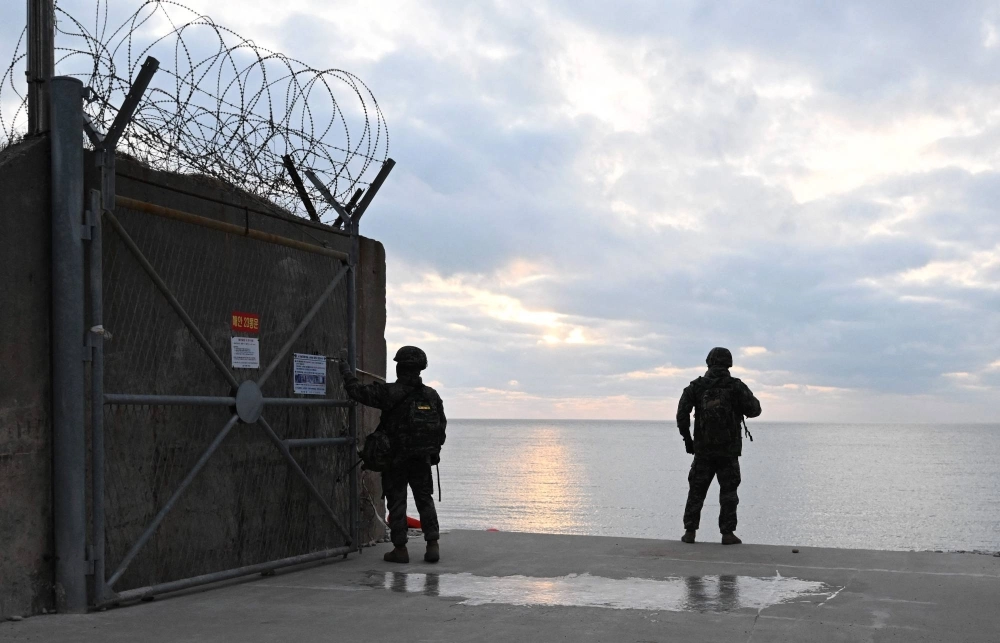 South Korean marines patrol the entrance to a beach on Yeonpyeong Island, near the Northern Limit Line sea boundary with North Korea, on Monday. South Korean marines patrol the entrance to a beach on Yeonpyeong Island, near the Northern Limit Line sea boundary with North Korea, on Monday.