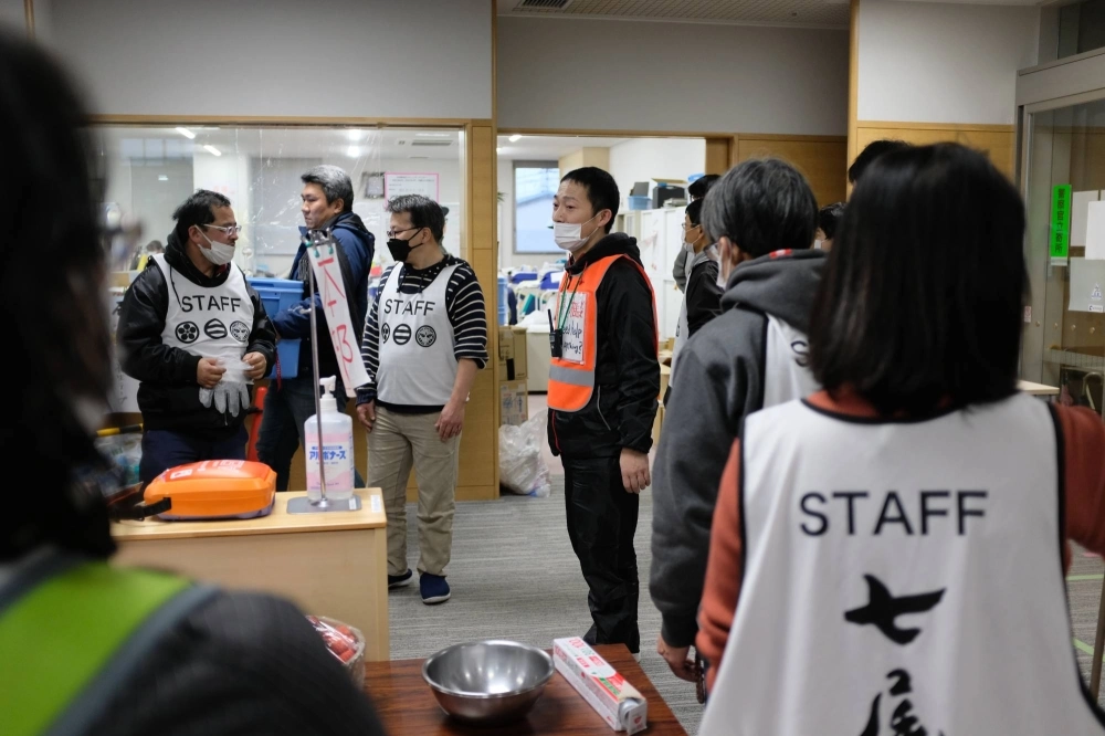 Shu Kokaji (center) speaks with fellow volunteers on Saturday at Sunlife Plaza, an evacuation center in Nanao, Ishikawa Prefecture. At the facility, he aims to bring people joy in some aspects of evacuee life. Shu Kokaji (center) speaks with fellow volunteers on Saturday at Sunlife Plaza, an evacuation center in Nanao, Ishikawa Prefecture. At the facility, he aims to bring people joy in some aspects of evacuee life.