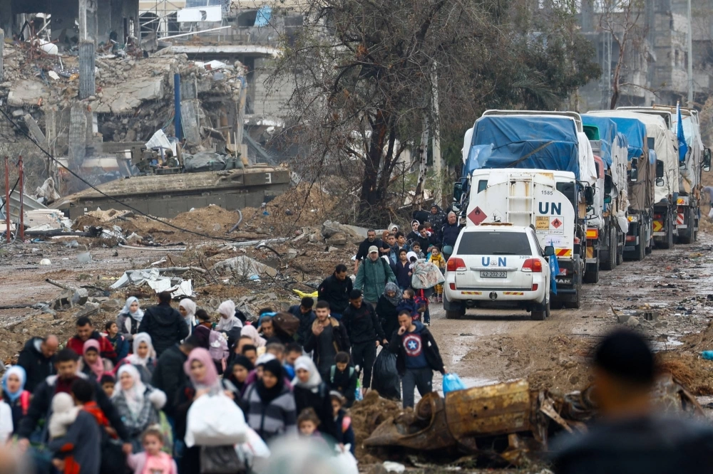 Palestinians fleeing northern Gaza move southward as trucks carrying aid and fuel head toward north Gaza during a temporary truce between Israel and Hamas, near Gaza City on Nov. 27. Palestinians fleeing northern Gaza move southward as trucks carrying aid and fuel head toward north Gaza during a temporary truce between Israel and Hamas, near Gaza City on Nov. 27.
