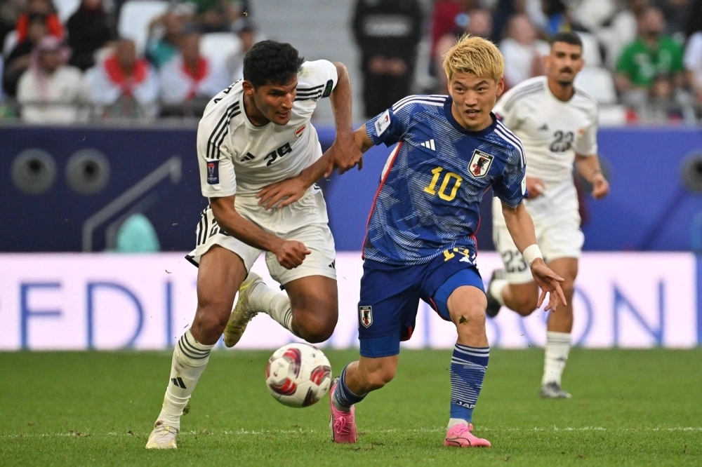 Iraq's Ahmed Yahya (left) and Japan's Ritsu Doan fight for the ball during their match at the Asian Cup on Friday. Iraq's Ahmed Yahya (left) and Japan's Ritsu Doan fight for the ball during their match at the Asian Cup on Friday.