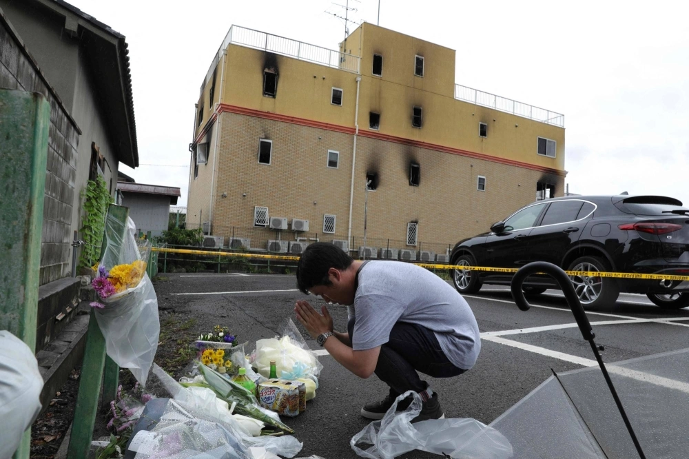 A man prays on July 19, 2019, outside the Kyoto Animation building where 36 people died in a fire caused by Shinji Aoba the previous day. A man prays on July 19, 2019, outside the Kyoto Animation building where 36 people died in a fire caused by Shinji Aoba the previous day.