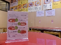 A menu at Masaka, a vegan restaurant in Tokyo’s Shibuya Ward, shows the rate of carbon dioxide emissions cuts for dishes compared with meat-based alternatives. | Tomoko Otake