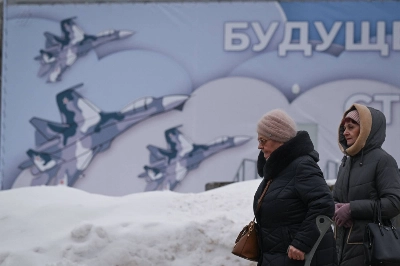 Women walk past an army-related billboard at the All-Russia Exhibition Center in Moscow on Jan. 24. Women walk past an army-related billboard at the All-Russia Exhibition Center in Moscow on Jan. 24.