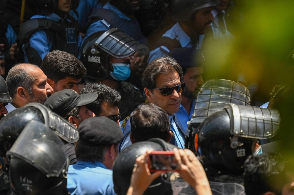 Police officers escort Pakistan's former Prime Minister Imran Khan (center) upon his arrival at the high court in Islamabad on May 12, 2023. Khan and his wife have been sentenced to 14 years' jail after being convicted of illegally selling gifts he received while he was premier. Police officers escort Pakistan's former Prime Minister Imran Khan (center) upon his arrival at the high court in Islamabad on May 12, 2023. Khan and his wife have been sentenced to 14 years' jail after being convicted of illegally selling gifts he received while he was premier.