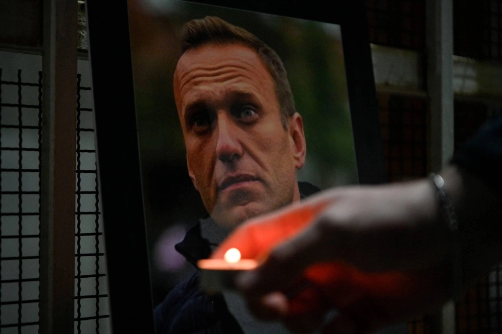 A person lights a candle by a portrait of late Russian opposition leader Alexei Navalny, who died in a Russian Arctic prison last week, at the entrance of Russian Embassy in Pristina, Kosovo, on Tuesday. A person lights a candle by a portrait of late Russian opposition leader Alexei Navalny, who died in a Russian Arctic prison last week, at the entrance of Russian Embassy in Pristina, Kosovo, on Tuesday.