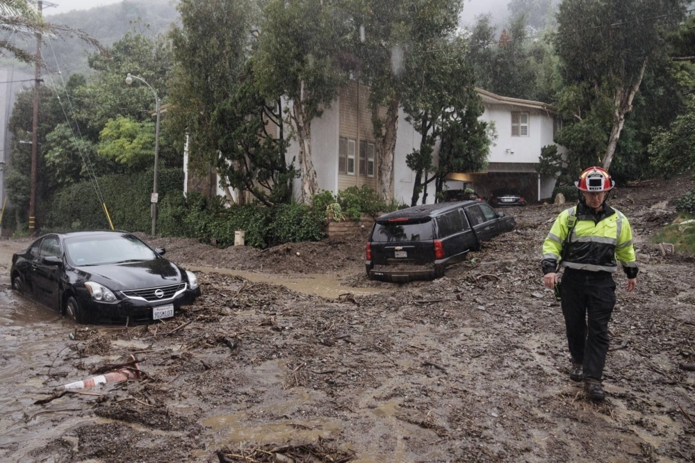A firefighter walks on mud and rocks from a mudslide during a storm in Los Angeles on Feb. 5. A firefighter walks on mud and rocks from a mudslide during a storm in Los Angeles on Feb. 5.
