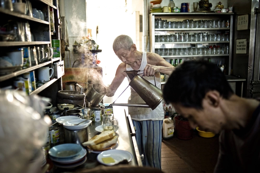 Shi Pong Hsu, 75, makes coffee in a Singapore coffee shop. The city-state's government projects that almost a quarter of its population will be 65 or over by 2030. Shi Pong Hsu, 75, makes coffee in a Singapore coffee shop. The city-state's government projects that almost a quarter of its population will be 65 or over by 2030.