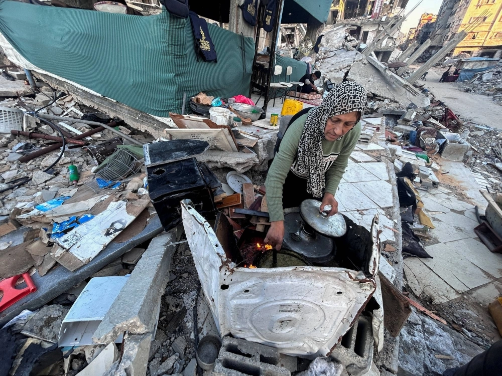 Palestinian Umm Nael Al-Khlout cooks breakfast on the rubble of her house which was destroyed during Israel's military offensive in Beit Lahia in the northern Gaza Strip on March 13. Palestinian Umm Nael Al-Khlout cooks breakfast on the rubble of her house which was destroyed during Israel's military offensive in Beit Lahia in the northern Gaza Strip on March 13.