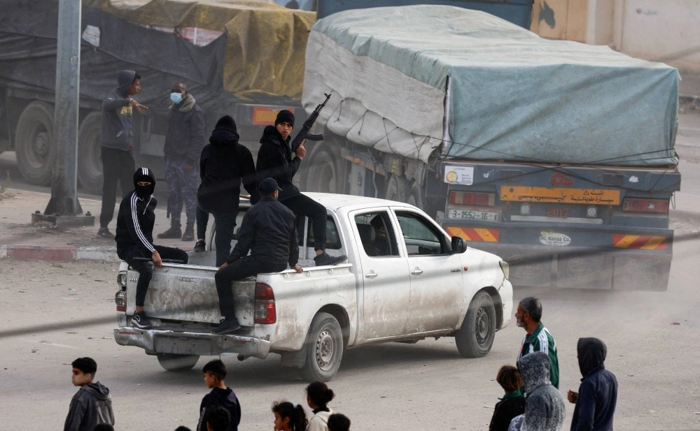 Security personnel guard trucks carrying aid as they arrive in the southern Gaza Strip on Jan. 17. Security personnel guard trucks carrying aid as they arrive in the southern Gaza Strip on Jan. 17.