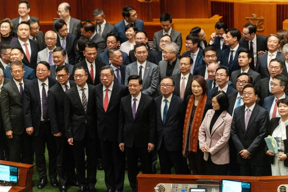 Hong Kong leader John Lee (center) with lawmakers after they passed the city's new security law. Hong Kong has fast-tracked into law domestic security legislation that critics say could muzzle open economic discussion and tighten control over foreign bodies operating in the global finance hub. Hong Kong leader John Lee (center) with lawmakers after they passed the city's new security law. Hong Kong has fast-tracked into law domestic security legislation that critics say could muzzle open economic discussion and tighten control over foreign bodies operating in the global finance hub.