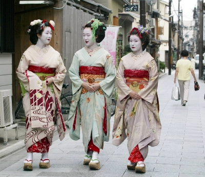 Tourists wearing rented 'maiko' costumes stroll down a street in Japan's ancient capital of Kyoto. Tourists wearing rented 'maiko' costumes stroll down a street in Japan's ancient capital of Kyoto.