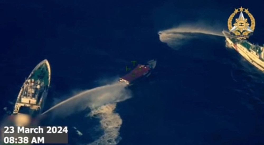 A screenshot from a video taken and released Saturday shows China Coast Guard ships deploying water cannons against a Philippine military-chartered civilian supply boat near the Second Thomas Shoal in disputed waters of the South China Sea. A screenshot from a video taken and released Saturday shows China Coast Guard ships deploying water cannons against a Philippine military-chartered civilian supply boat near the Second Thomas Shoal in disputed waters of the South China Sea.