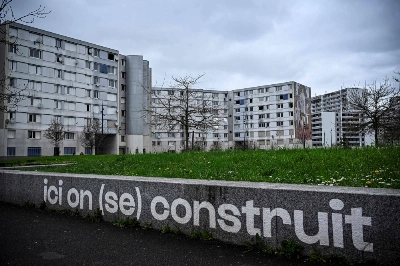 A view of apartment buildings with writing on a wall that reads "Here we build (ourselves)," in the Franc-Moisin neighborhood of Saint-Denis, a northern Paris suburb, on March 13. The Seine-Saint-Denis department north of Paris will host a number of events for the Paris 2024 Olympic and Paralympic Games, with venues including the Stade de France and Aquatics Centre, as well as the Olympic Village. A view of apartment buildings with writing on a wall that reads "Here we build (ourselves)," in the Franc-Moisin neighborhood of Saint-Denis, a northern Paris suburb, on March 13. The Seine-Saint-Denis department north of Paris will host a number of events for the Paris 2024 Olympic and Paralympic Games, with venues including the Stade de France and Aquatics Centre, as well as the Olympic Village.