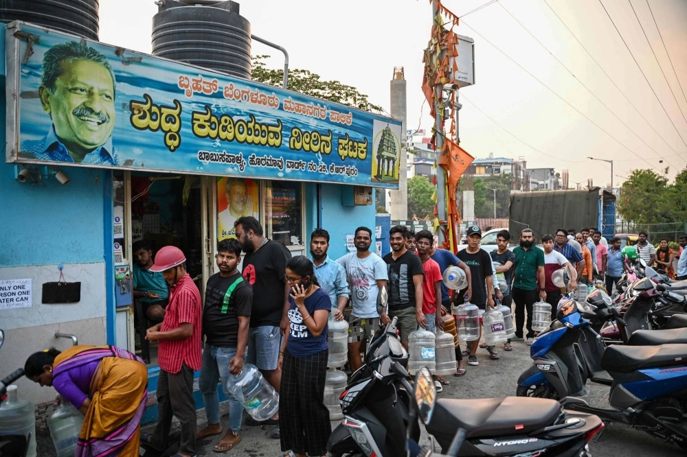 People wait to collect drinking water on March 14 amid an ongoing water crisis in Bengaluru, which has been hit by drought. People wait to collect drinking water on March 14 amid an ongoing water crisis in Bengaluru, which has been hit by drought.