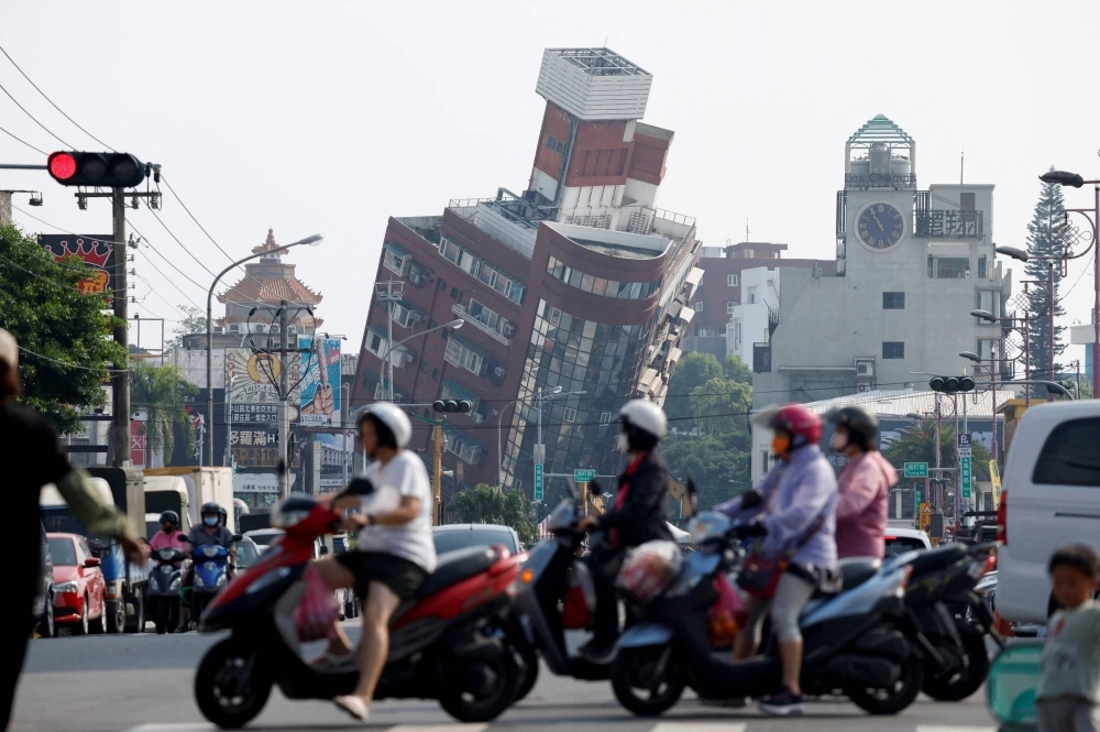 People ride motorcycles near the site where a building collapsed, following the earthquake, in Hualien, Taiwan, on Thursday. People ride motorcycles near the site where a building collapsed, following the earthquake, in Hualien, Taiwan, on Thursday.