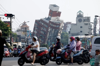 People ride motorcycles near the site where a building collapsed, following the earthquake, in Hualien, Taiwan, on Thursday. People ride motorcycles near the site where a building collapsed, following the earthquake, in Hualien, Taiwan, on Thursday.